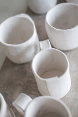 Fototapeta na wymiar White handmade clay cups. Tea set on the table. White kitchen items