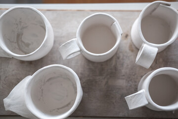 White handmade clay cups. Tea set on the table. White kitchen items