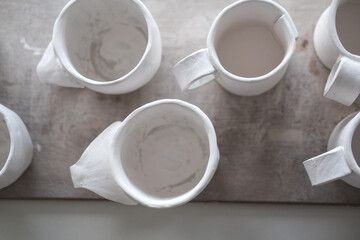 Fototapeta na wymiar White handmade clay cups. Tea set on the table. White kitchen items