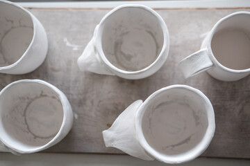 Obraz na płótnie Canvas White handmade clay cups. Tea set on the table. White kitchen items