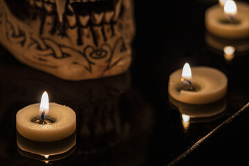 Teschio illuminato da candele con sfondo nero