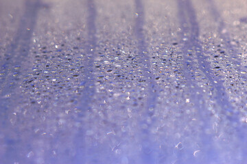 wet window glass with water drops and lines in sunny day - close up, water background