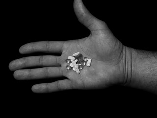 Antidepressants drug pills on man palm on black background