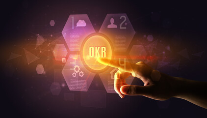 Hand touching OKR inscription, new technology concept