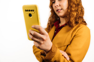 Closeup shot of a female holding her smartphone on an isolated background. selective focus.