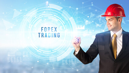 Handsome businessman with helmet drawing FOREX TRADING inscription, contruction business concept