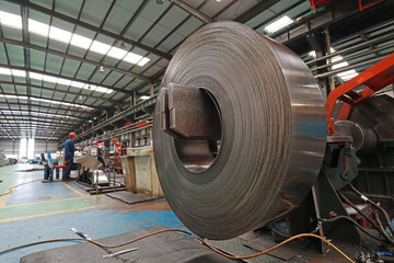 Workers are busy on the strip production line in an iron and steel company.