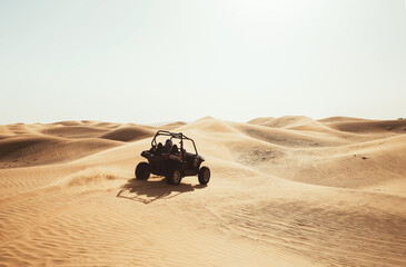 Silhouette of buggy quad bike in desert sand dunes during safari tour, extreme driving fun...