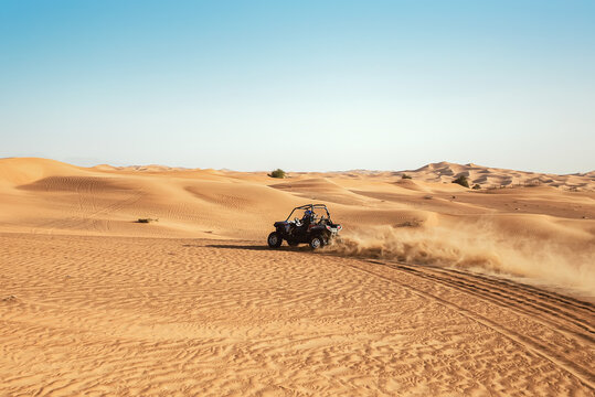  Quad buggy bike drift at desert sand dunes during safari tour at sunny day 