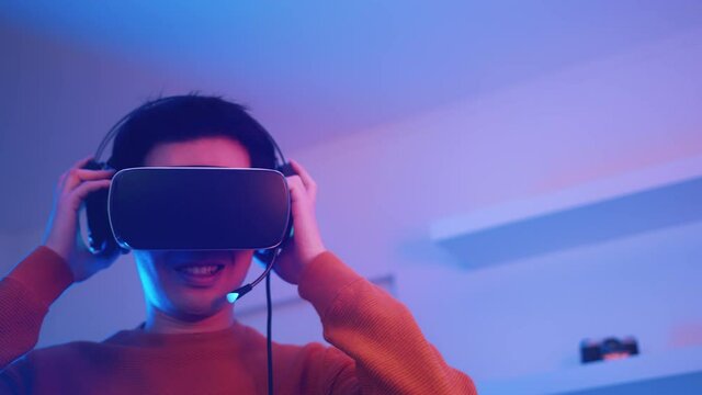 Virtual reality. Happy smiling asian man with VR headset . High quality 4k footage