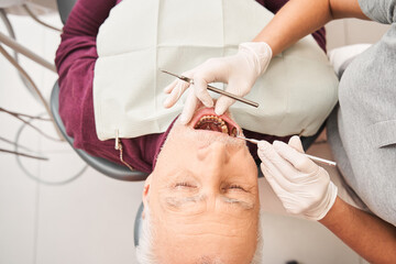Obraz na płótnie Canvas Dentist using some tools for treating dentist teeth