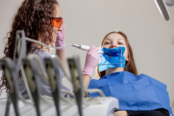 Close-up portrait of a female patient visiting dentist for teeth whitening in clinic