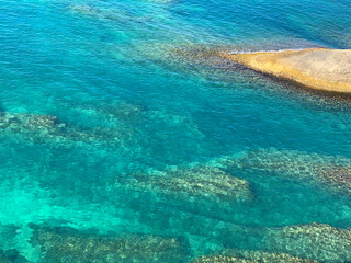 Fototapeta na wymiar Sea blue turquoise clear water summer Mediterranean rocky coast. Shiny emerald green ocean waters background. Relax, summertime, zen, meditation, tropical paradise. Transparent aquamarine watercolor.