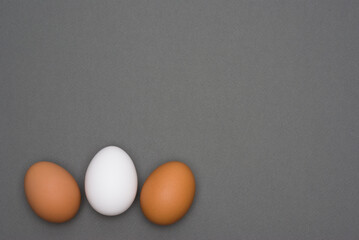 White and brown eggs on gray background. Easter. Top view
