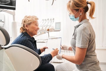 Doctor waiting while client signing the documents