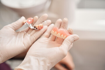 Dentist holding dentures in office room