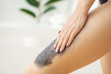 Obraz na płótnie Canvas Skin care, woman applies black scrub with sea salt