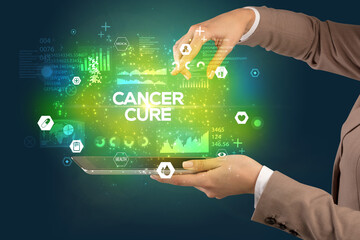 Close-up of a touchscreen with CANCER CURE inscription, medical concept