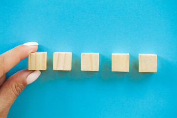 Hand putting and stacking blank wooden cubes on table with copy space for input wording and...