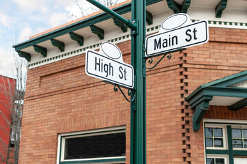 A vintage or retro street sign for High and Main streets in front of a turn of the century brick building in Priest River, Idaho, USA
