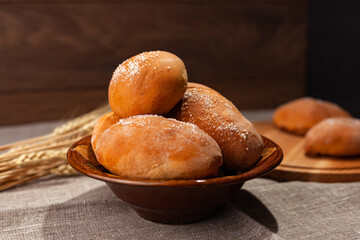 pies and homemade pastries in a plate, wheat. Dark background