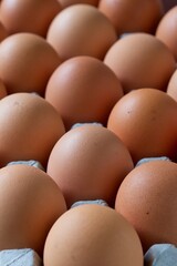 A close up shot of some fresh farm eggs on a cardboard egg tray.