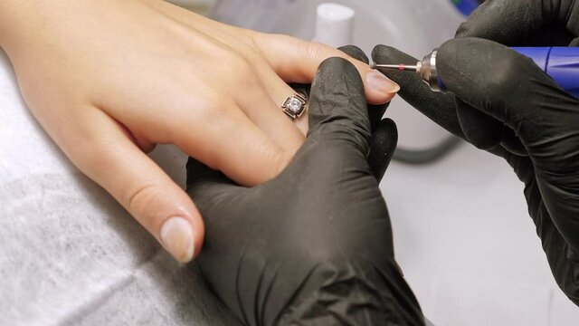 Manicure process. Correction of female nails with drilling machine