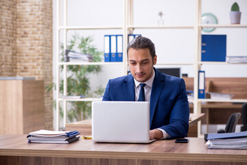 Obraz premium Young male employee working in the office