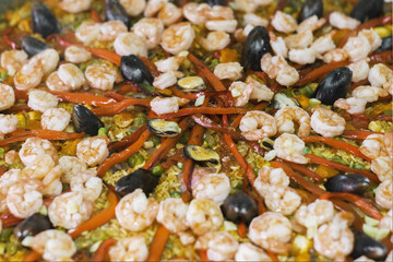 Detalle de una paella con pulpo, carne, mejillones, pimentón rojo, camarones, habichuela, alverja y zanahoria