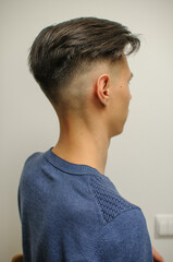 Young man with modern short haircut in beauty salon