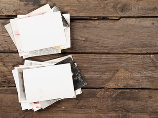 On wooden table two piles of old retro photos with copy space. Flat lay.