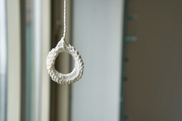 white rope loop hanging against blurry background
