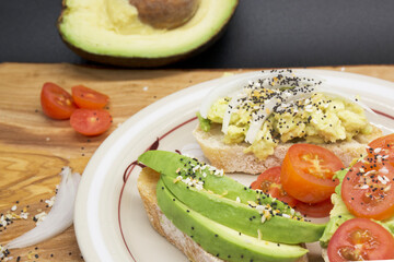  avocado toasts with seeds and tomatoes on wooden board, dark background. Top view of avocado sandwiches. Food photo, healthy food.