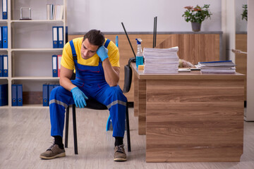Young male contractor cleaning the office