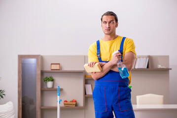 Young male contractor cleaning the house