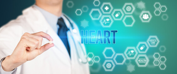 Close-up of a doctor giving you a pill with HEART inscription, medical concept