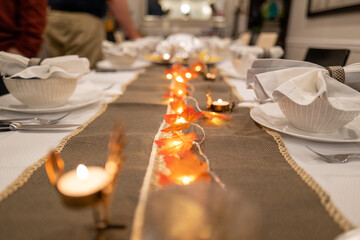 thanksgiving themed table setting with leaves and fairy lights