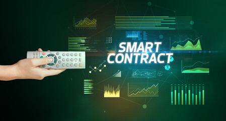 hand holding wireless peripheral with SMART CONTRACT inscription, cyber business concept