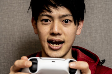 ゲーム中毒の若い男性,寝癖のある男性,ゲームコントローラーをもつ男,