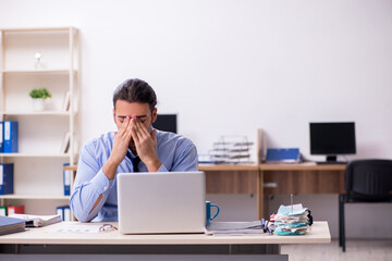 Sick male employee suffering at workplace