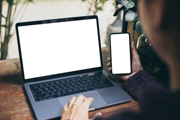 computer screen,cell phone blank mockup.hand woman work using laptop texting mobile.with white...
