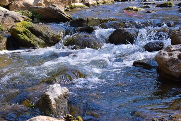 flowing water into a river against rocks
