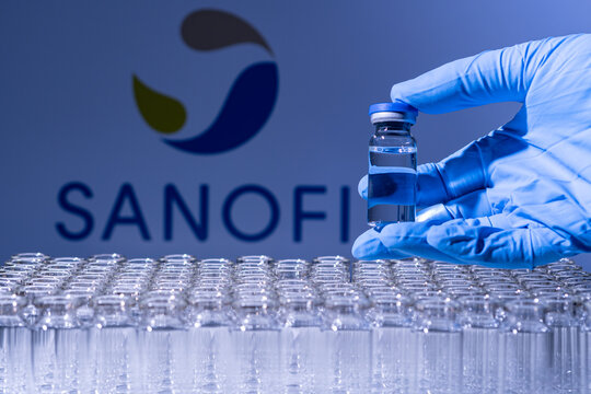 Toronto, Ontario, Canada - February 14, 2021 : Sanofi o name in blur. Vaccine scientist holding the glass vial with French vaccine. Research against Coronavirus, COVID-19. Clinical evaluation.