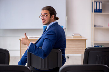 Fototapeta premium Young male business trainer in the office during pandemic