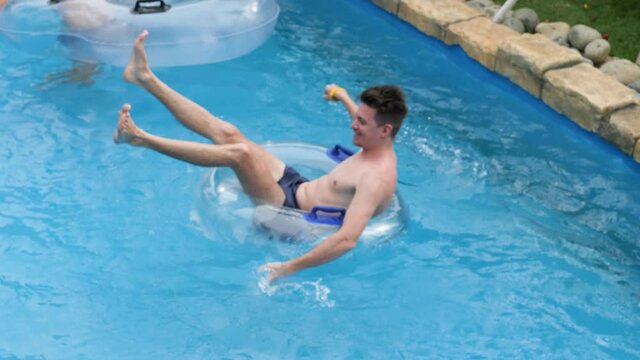 Young Caucasian Men Enjoying The Float Ride In The Lazy River At A Waterpark On Summer Day.