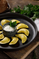 Appetizing traditional Russian dumplings made by hand with delicious filling. Still life on a wooden board. Close-up.