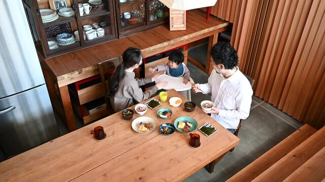 和室の広い部屋で美人なママと家族団らんの幸せな若いファミリーの俯瞰動画　下にコピースペースあり