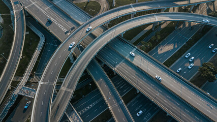 Top up aerial drone view of elevated road and traffic junctions in Chinese metropolis city Chengdu during sunny day. Modern construction design of traffic ways to avoid traffic jams. Few vehicles.