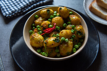 Indian food item dum aloo or potatoes cooked in slow fire in a bowl. Close up, selective focus.