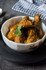 Popular Indian dish chicken amritsari in gravy and bread slices. View from top, selective focus.